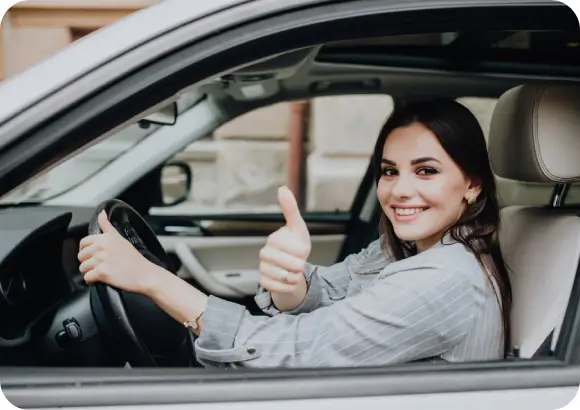 Happy student holding DMV test certificate outside AAA Driving School